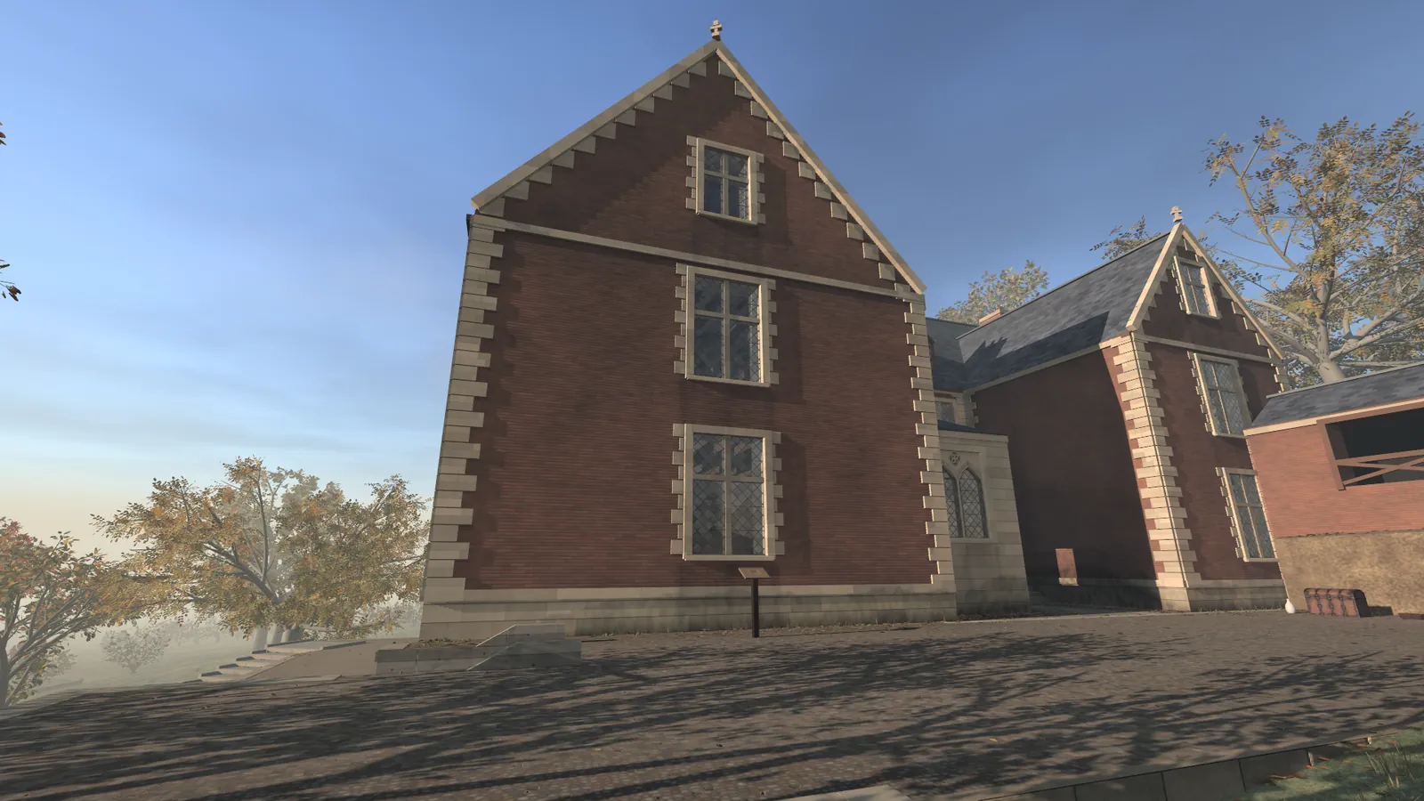 A tall brick house with stone corners and a steep gable, seen across a paved terrace in low sun, trees in autumn leaves at its sides. In front of it a small stand on a post. A still from the museum's film. The house is a reconstruction built in code.