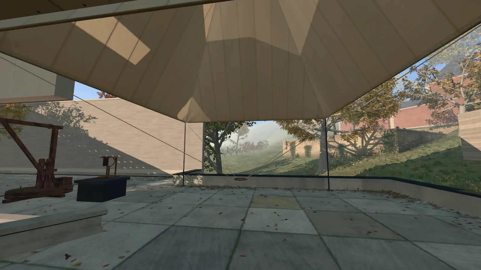 The underside of the parachute, a pyramid of pale linen, fills the top of the picture. Below it a paved court with fallen leaves, at the left a wooden crane and a small anemometer on a plinth, and trees in autumn colours beyond a low wall.